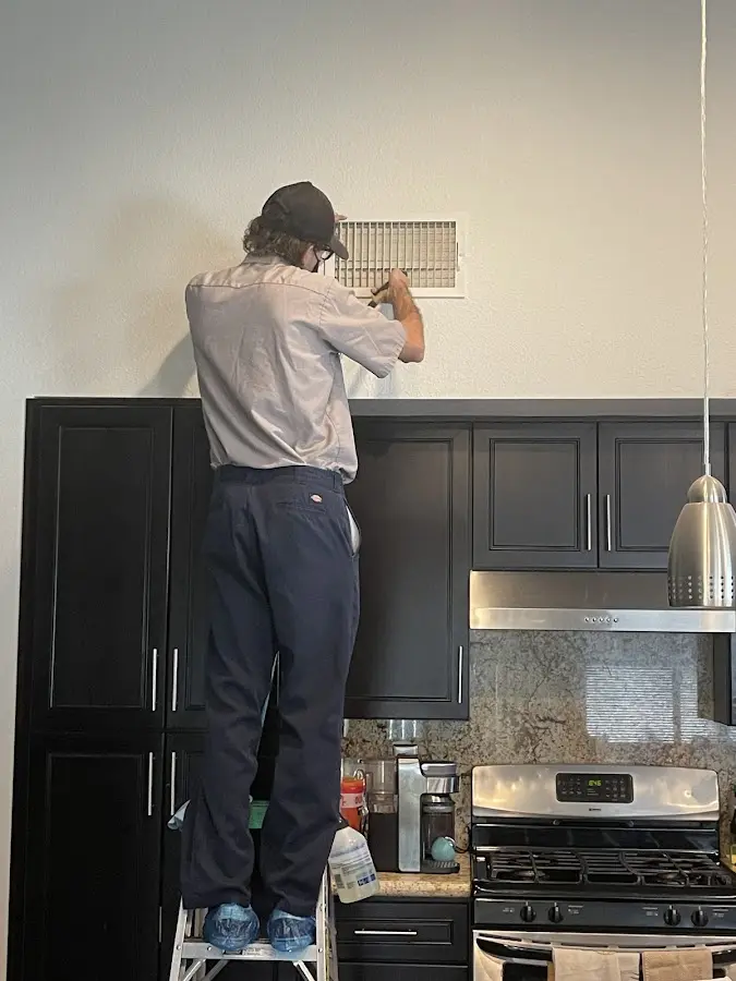 Technician inspecting an air vent during HVAC service in Mechanicsburg